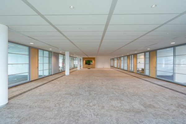Ruime, lege kantoorruimte aan de Fascinatio Boulevard met glazen wanden en een licht interieur.